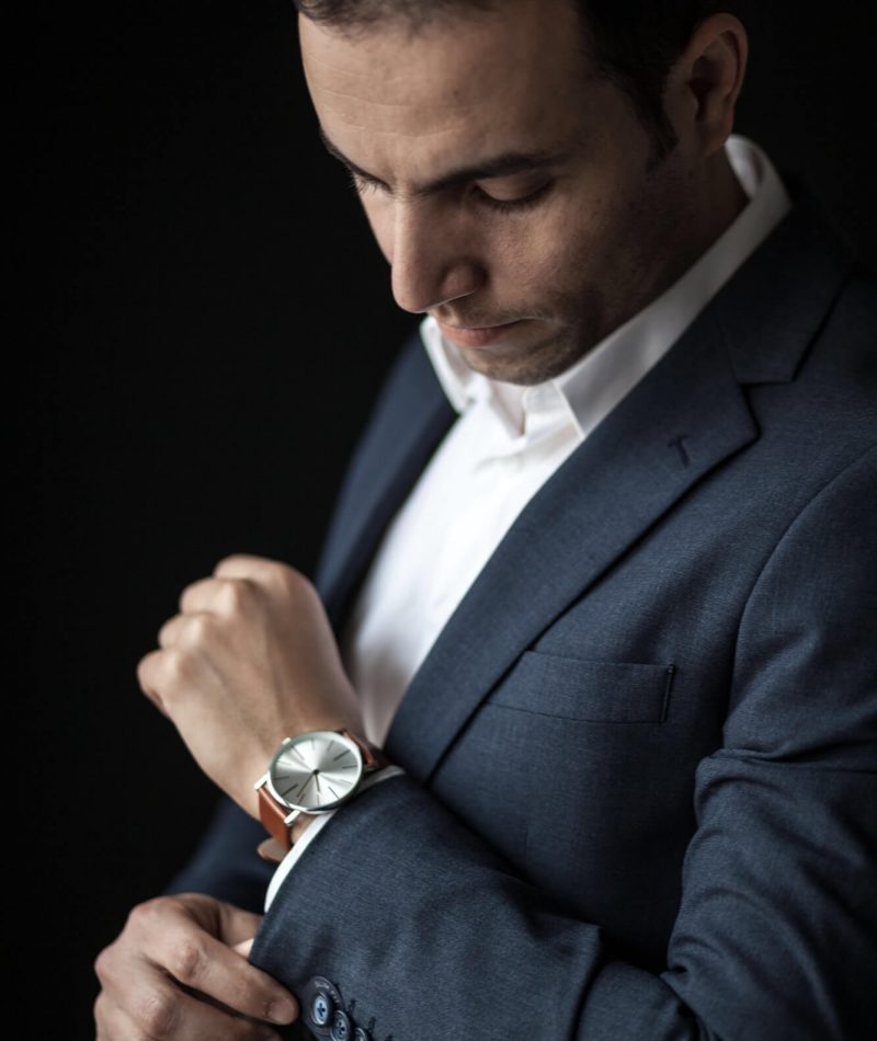 man-adjusting-his-sleeves-wearing-a-watch